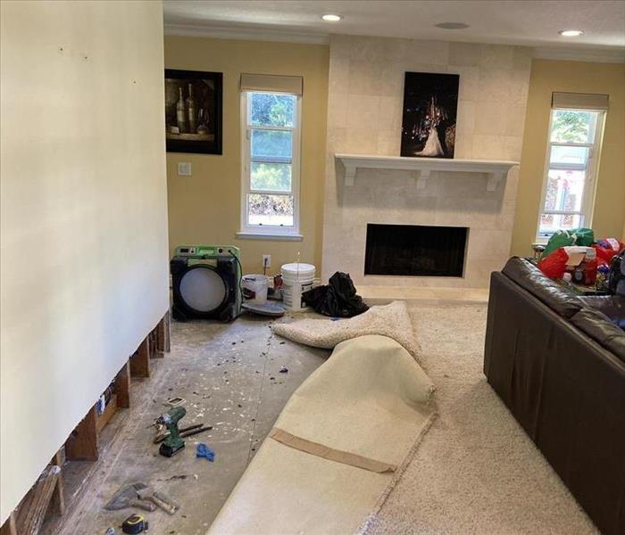 Family room with walls cut and carpet being removed 